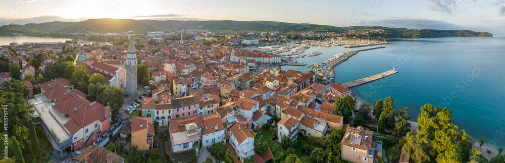 Aerial panoramic view of picturesque Izola town with the old town and buildings with red roofs, the main promenade, the marina with boats on Adriatic sea coast, Slovenia.