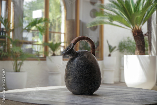 Rustic Elegance: A Black Ceramic Jug Graces a Wooden Table
