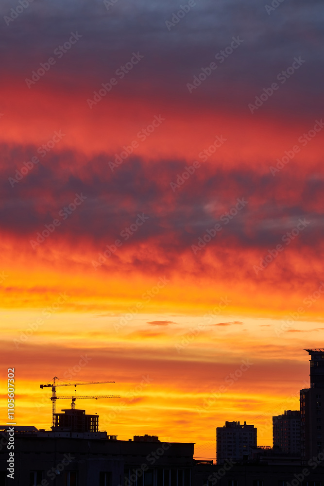 Crane and Buildings Silhouetted Against a Vibrant Sunset Crane and Buildings Silhouetted Against a Vibrant Sunset