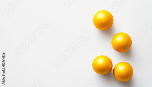 Four vibrant yellow balls arranged artistically on a white background.