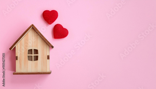 Wooden house with decorative hearts on pink background. New home, love and romantic. Flat lay.