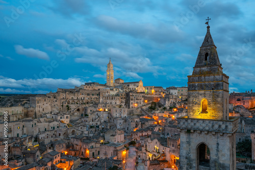 Ancient city view with traditional stone houses, Maria Santissima della Bruna and Sant'Eustachio Cathedral and Church of Saint Peter Barisano at sunset, Matera, Basilicata, Italy photo