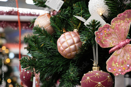 Decorative pink butterfly on a Christmas tree.