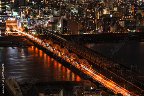 Traffic on bridges crossing the Yodo River and midnight night skyline of Osaka, Honshu, Japan photo