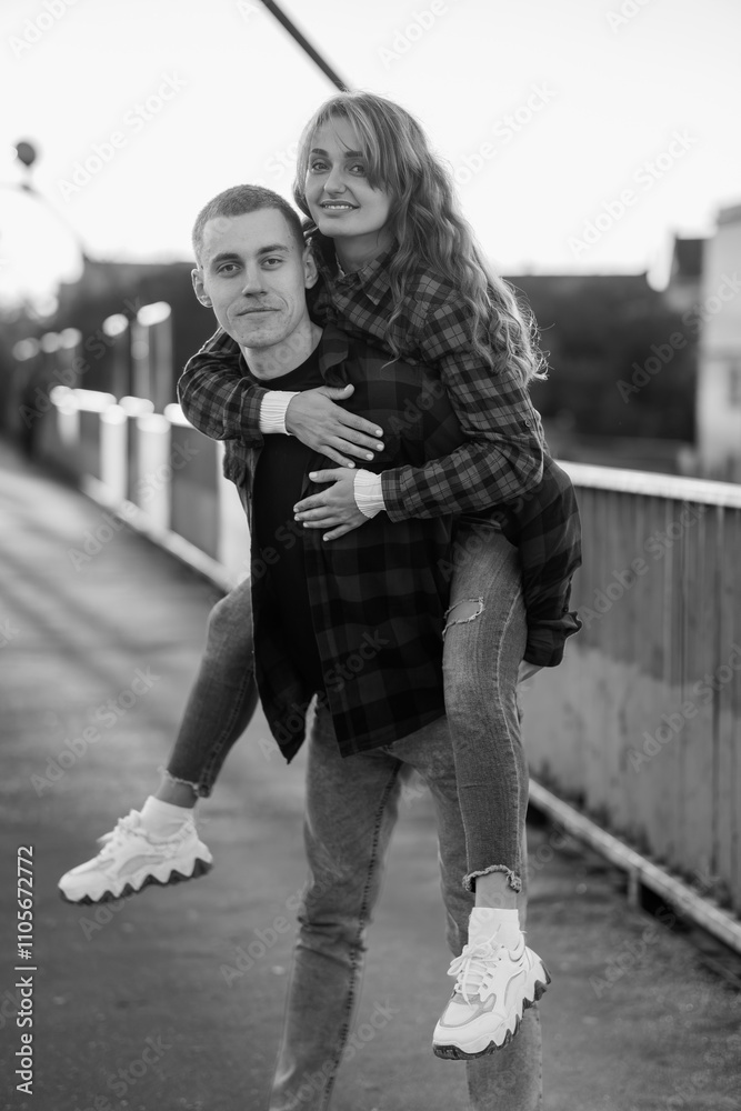 A Joyful Couple Embracing Love in a Playful Moment on a Sunlit Bridge A Joyful Couple Embracing Love in a Playful Moment on a Sunlit Bridge