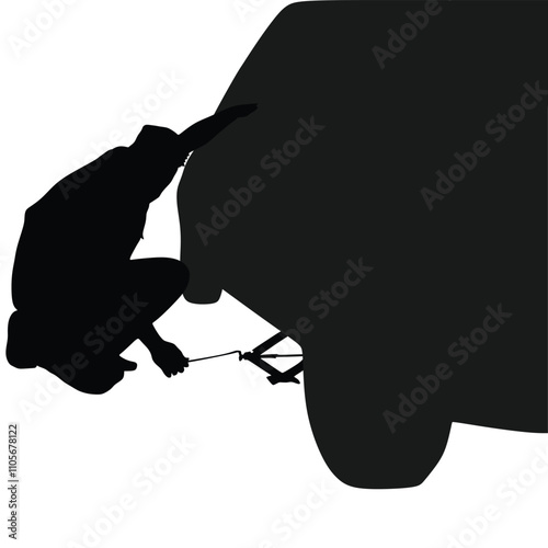 Silhouette of a man trying to lift a car with a jack and change a tire