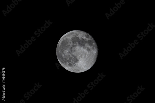 Obraz na płótnie A close-up shot of the full moon captured through a telephoto lens, revealing its surface with visible craters, showcasing the moon's detailed and captivating features w salonie