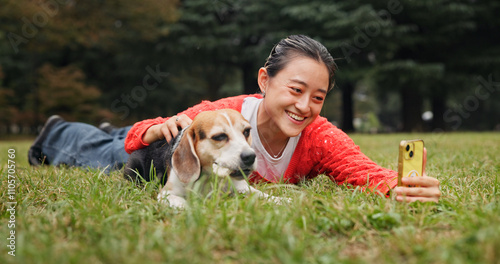 Selfie, outdoor and woman relaxing with dog for memory, social media or online post in woods. Happy, bonding and Japanese female person on grass with beagle puppy for photography picture in nature. photo