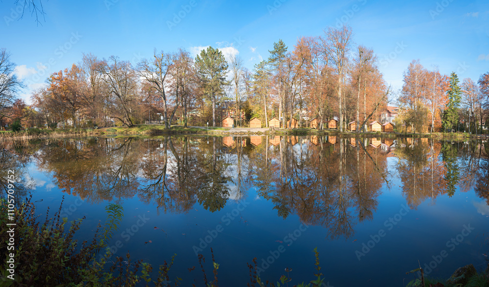 lake Irlachsee, spa garden Bad Aibling, with wooden huts for christmas market, water reflection lake Irlachsee, spa garden Bad Aibling, with wooden huts for christmas market, water reflection