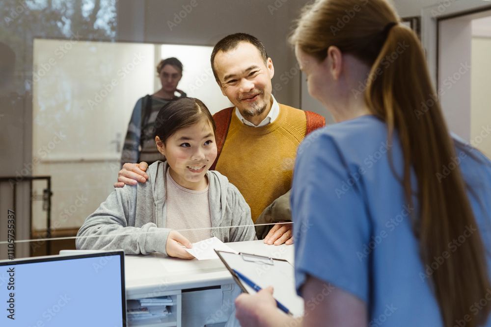 Father and daughter booking doctor's appointment at healthcare center Father and daughter booking doctor's appointment at healthcare center