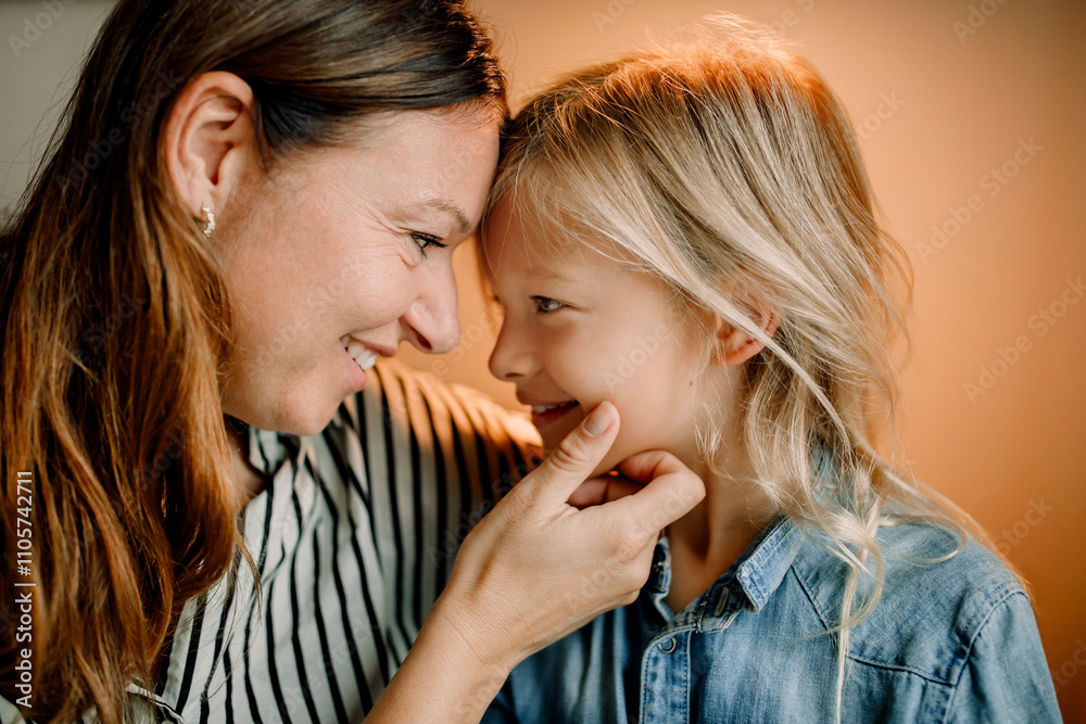 Smiling mother touching chin of son with long blond hair at home Smiling mother touching chin of son with long blond hair at home