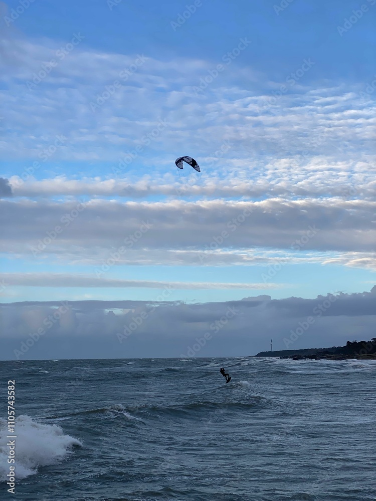 Kitesurfer soaring over ocean waves under a vibrant sky. Kitesurfer soaring over ocean waves under a vibrant sky.