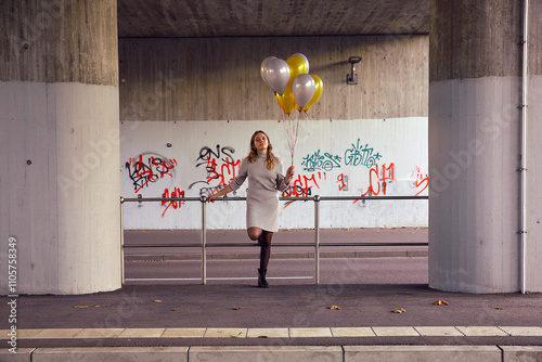 Frau mir Luftballons an der Haltestelle