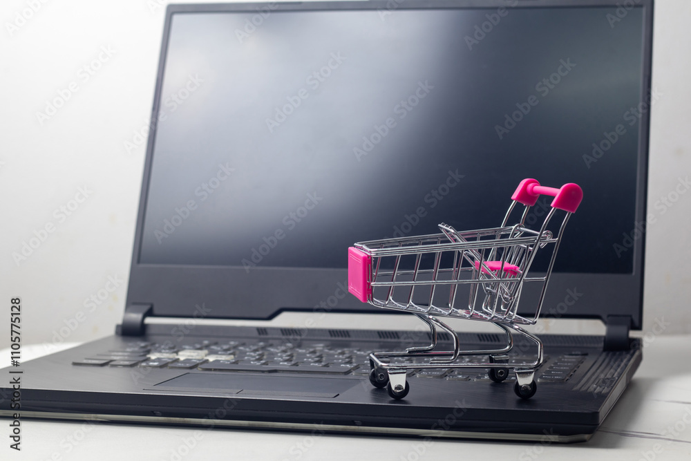 Empty shopping cart on laptop keyboard, ecommerce mockup template with copy space Empty shopping cart on laptop keyboard, ecommerce mockup template with copy space
