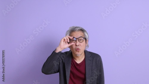 Wallpaper Mural A senior East Asian businessman in a blazer stands against a purple background. Torontodigital.ca