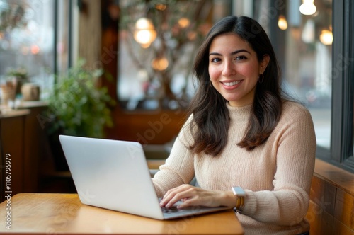 Hispanic young female working on laptop in cozy café atmosphere.