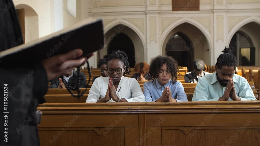 Priest holding bible leading congregation in prayer slow motion