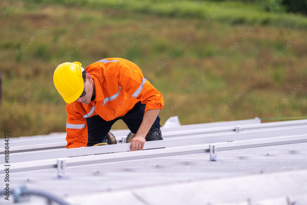 Worker in an orange safety uniform and helmet carefully inspecting a metal rooftop under natural daylight. Depicts diligence, precision, and professional commitment in construction and maintenance. Worker in an orange safety uniform and helmet carefully inspecting a metal rooftop under natural daylight. Depicts diligence, precision, and professional commitment in construction and maintenance.