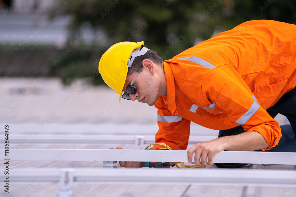 Technician on a rooftop in an orange safety uniform and helmet using tools to install a metal frame. Depicts precision, safety, and expertise in rooftop construction and renewable energy projects. Technician on a rooftop in an orange safety uniform and helmet using tools to install a metal frame. Depicts precision, safety, and expertise in rooftop construction and renewable energy projects.