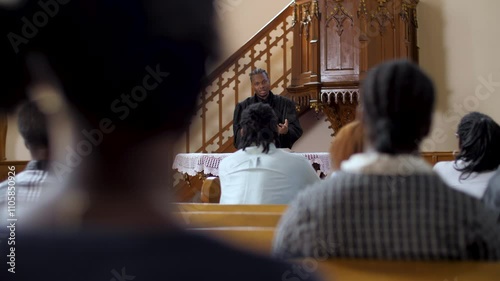 Congregation listening to priest giving sermon in church slow motion