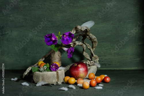 design, composition, ikebana, still life of summer wildflowers, tree roots, apples, plums, bird feathers, Ipomeia flowers photo