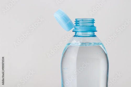 Close up of new cap attached to plastic bottle, connected to the neck of the bottle by solid tab attached to safety ring. They are intended to encourage recycling, as part of the fight against litter
