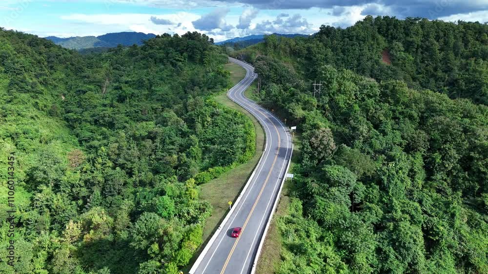Aerial view of motorcycle driving on country road in forest. Cinematic drone shot flying over country road with curved in the mountain. Aerial view of motorcycle driving on country road in forest. Cinematic drone shot flying over country road with curved in the mountain.