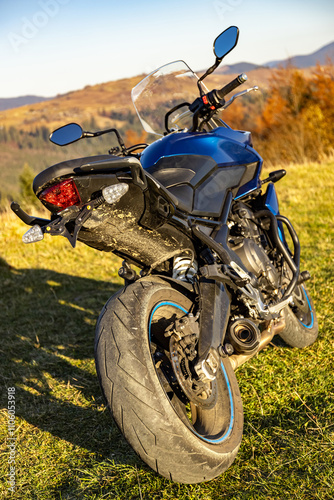 Sport motorcycle parked, view from the rear wheel. photo