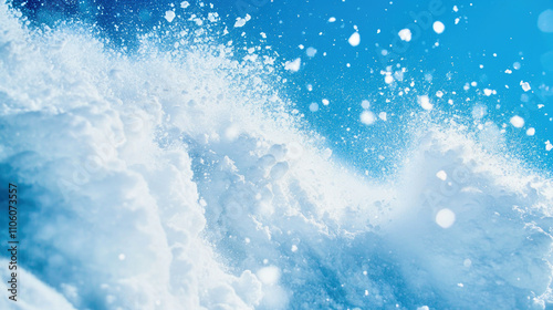 Avalanche tumbles down steep mountain slope under a clear blue winter sky