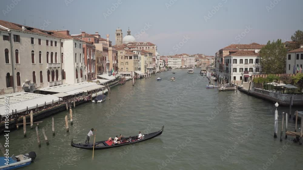 Gondolier navigating tourists through picturesque venice canal Gondolier navigating tourists through picturesque venice canal
