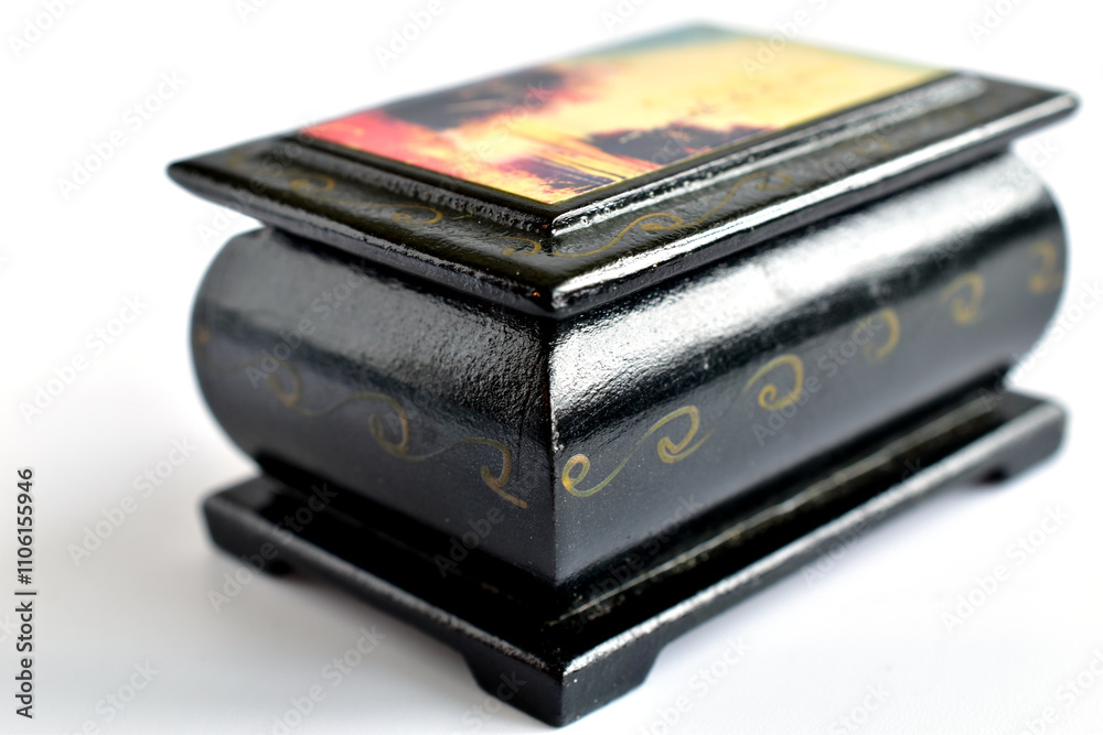 A box made of black wood with a pattern on the lid stands on a white background. A box made of black wood with a pattern on the lid stands on a white background.