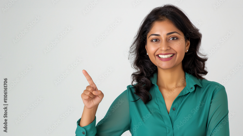 Image of a beautiful, smiling Indian woman posing and pointing her finger to the side. The image is blank, advertising, communication. Image of a beautiful, smiling Indian woman posing and pointing her finger to the side. The image is blank, advertising, communication.