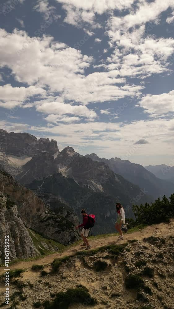 vertical drone video of caucasian couple summertime making trekking with red backpack at popular path of scenic fantastic view of Italian Dolomites Cadini di Misurina vertical drone video of caucasian couple summertime making trekking with red backpack at popular path of scenic fantastic view of Italian Dolomites Cadini di Misurina