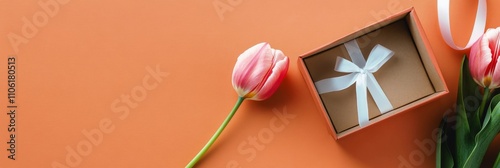 Gift box and tulip on an orange background create a warm and inviting atmosph...