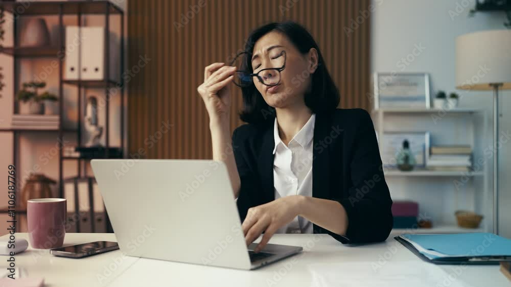 Overworked businesswoman experiences eye tension while working on her laptop Overworked businesswoman experiences eye tension while working on her laptop