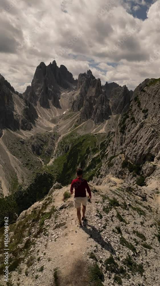 vertical drone video of scenic fantastic view of Italian Dolomites Cadini di Misurina and a caucasian young man admiring the view and dancing vertical drone video of scenic fantastic view of Italian Dolomites Cadini di Misurina and a caucasian young man admiring the view and dancing