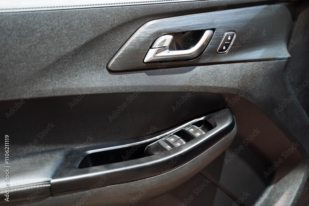 Naklejka premium This image features a detailed close up of a car door prominently displaying the intricate design of a door handle, which is an essential component of the vehicles accessibility and style