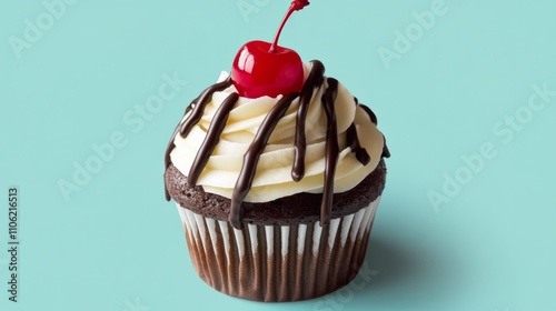 Delicious chocolate cupcake topped with cherry and drizzled icing on light bl...