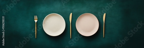 Elegant table setting with gold cutlery and simple dishes on dark green backg...