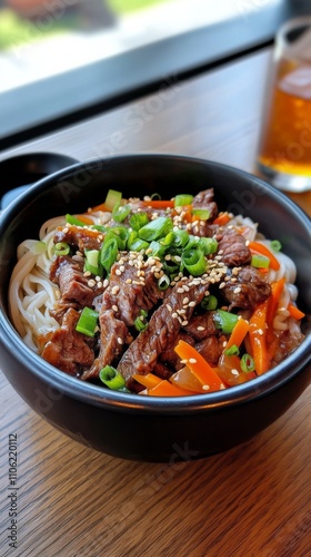 Savory beef stir fry served in a black bowl garnished with vegetables and sauce