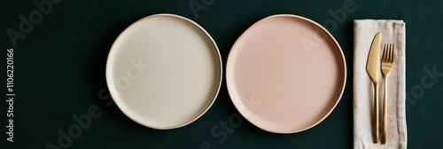 Elegant table setting with gold cutlery and simple dishes on dark green backg...