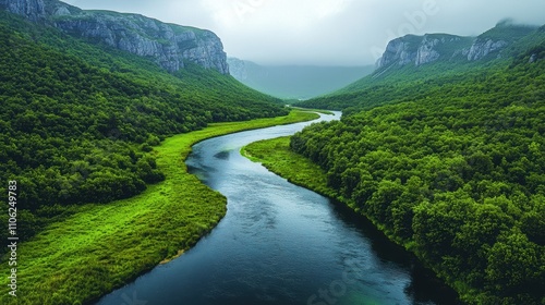 Winding River Through Lush Green Valley Under Cloudy Sky