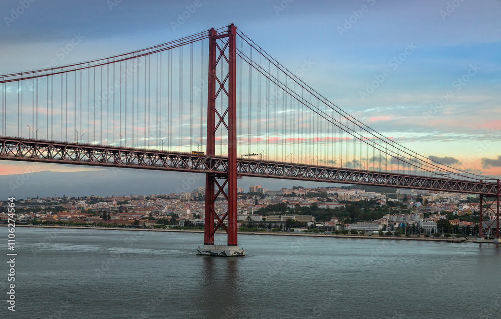 Fototapeta premium Panoramic Exposure done from a Cruise ship, while arriving at Lisbon at sunrise, of the 25th April Bridge and Tagus River, with Lisbon on the left bank and the Sanctuary of Christ the King, Lisbon,Por