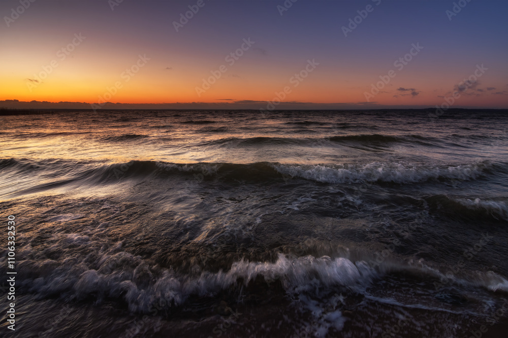 waves with breakers in stormy weather in a large raging lake in the warm light of the evening dawn. picturesque surf close-up, side view from below waves with breakers in stormy weather in a large raging lake in the warm light of the evening dawn. picturesque surf close-up, side view from below