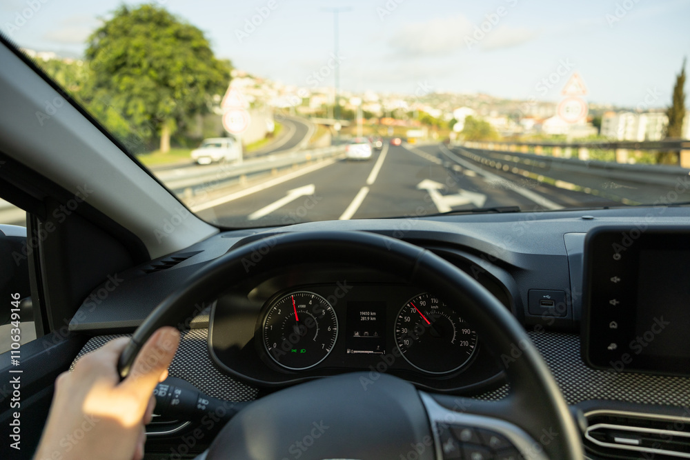 Driver view to the speedometer, with hand on the steering wheel. Blurred road. Madeira island, Portugal. Driver view to the speedometer, with hand on the steering wheel. Blurred road. Madeira island, Portugal.