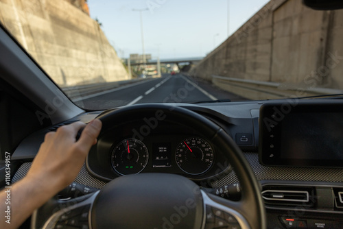 Driver view to the speedometer, with hand on the steering wheel. Blurred road. Madeira island, Portugal.