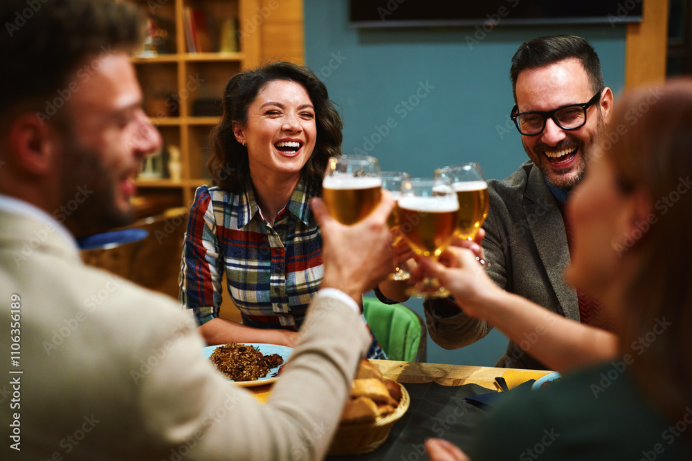 Cheerful friends are toasting laughing and enjoying their time together during a meal at a restaurant Cheerful friends are toasting laughing and enjoying their time together during a meal at a restaurant