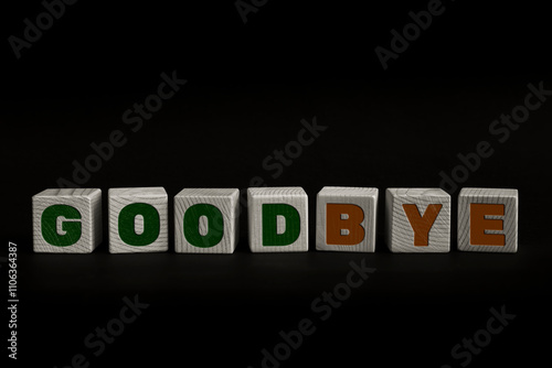 Word GOODBYE written with wooden cubes. Studio shot of some arranged wooden blocks with a textual message.