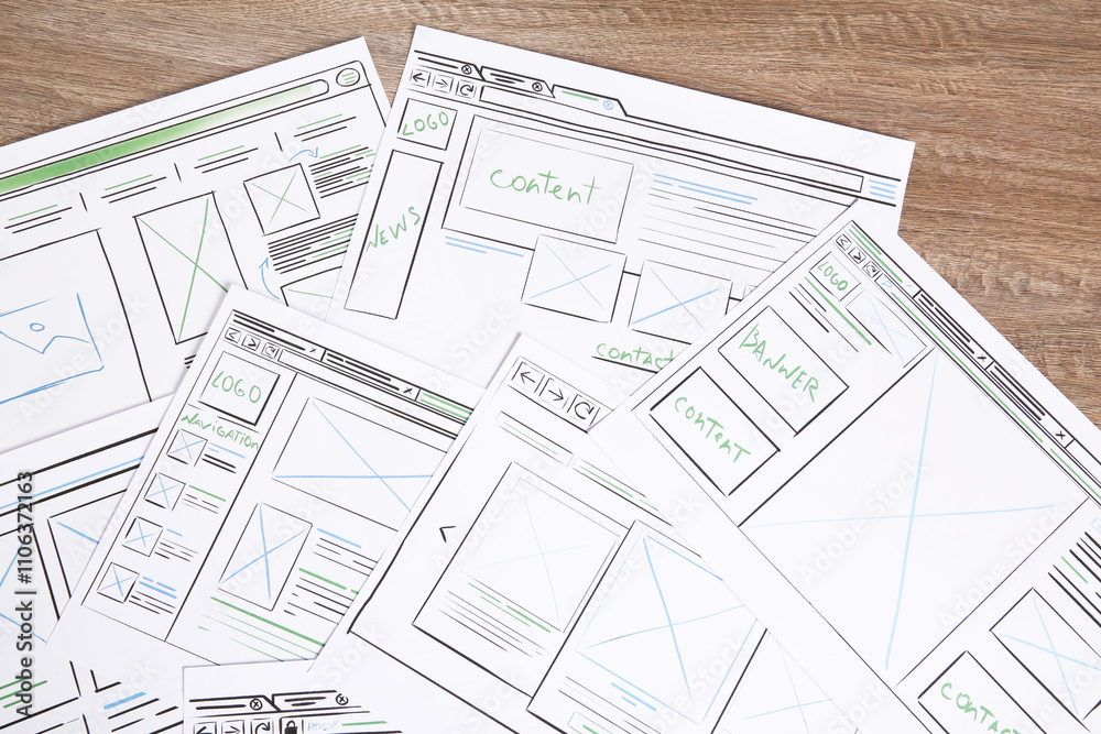 Developing UI design. Sketches of website wireframes on wooden table, top view Developing UI design. Sketches of website wireframes on wooden table, top view