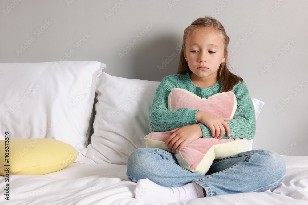 Autism concept. Lonely little girl with pillow on bed at home Autism concept. Lonely little girl with pillow on bed at home